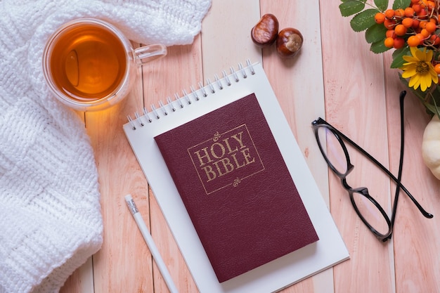 Holy bible and autumn cozy top view on wooden background Bible study autumn concept