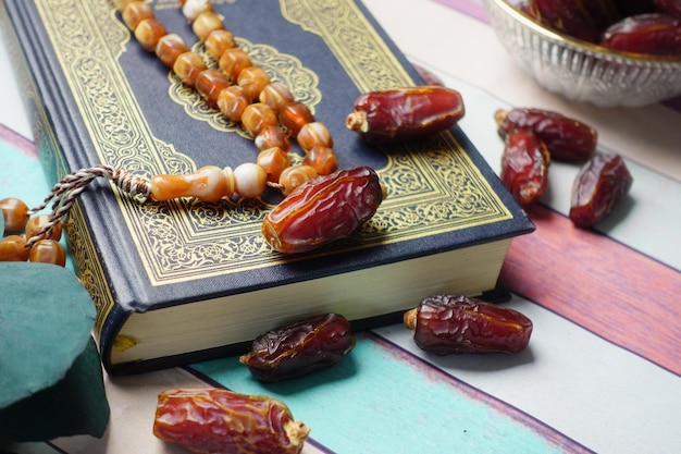 Holy book quran and rosary on table close up