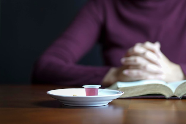 Holy Communion wine and bread with woman praying at the background