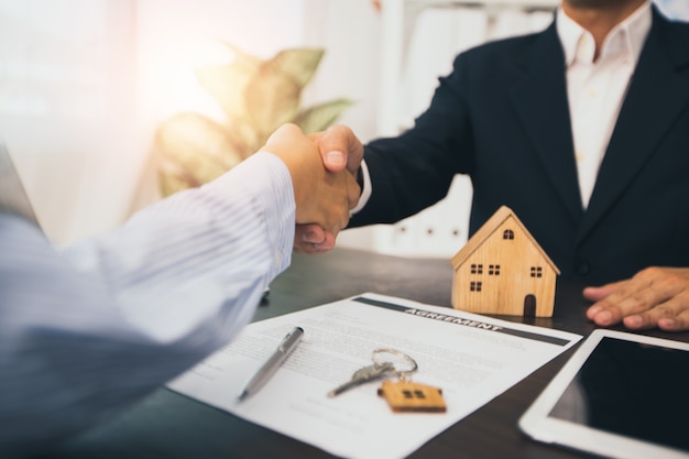 Home agent shakes hands with customer after sign contract