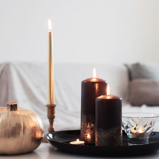 Home decor with golden pumpkin and burning candles