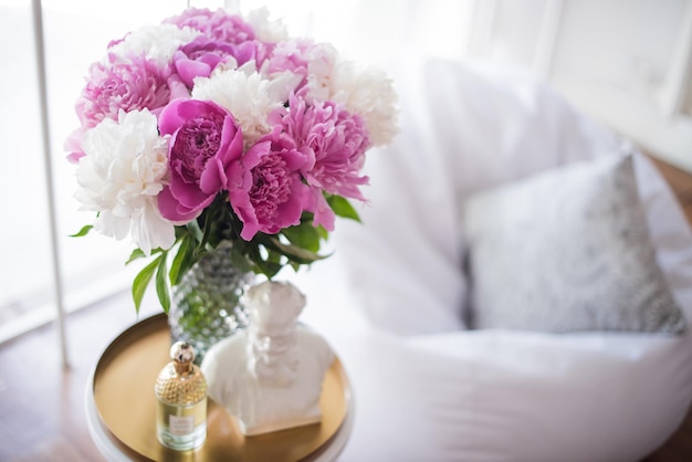 Home decoration fresh pink peonies on coffee table in white roo