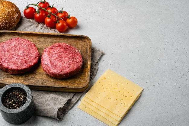 Home Handmade Raw Minced Beef steak burgers on gray stone table background with copy space for text