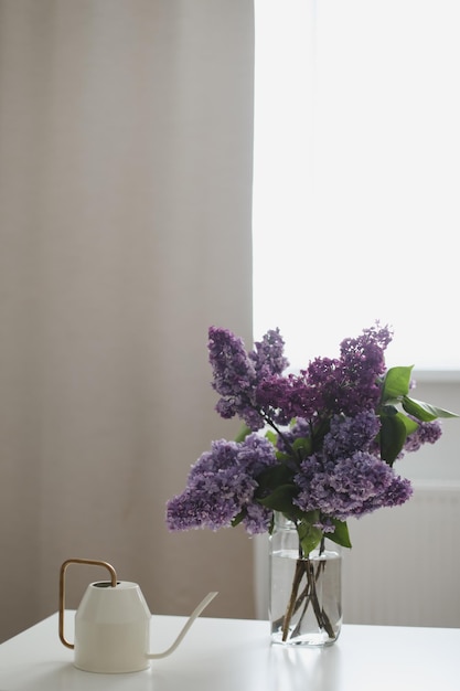 Home interior decor bouquet of lilacs in a vase on table