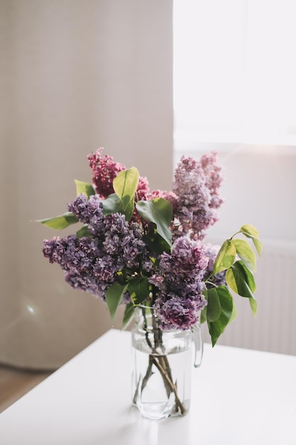 Home interior decor bouquet of lilacs in a vase on table