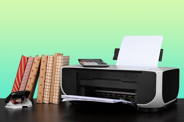 Home laser printer on desk against green background