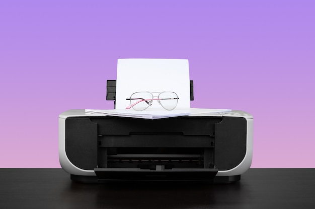 Home laser printer on desk against purple background