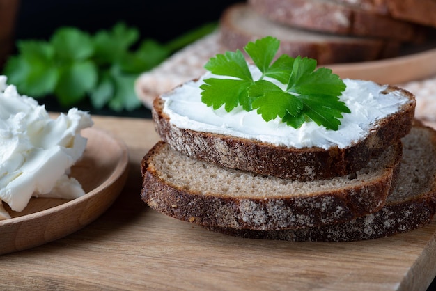 Home made bread on a wooden cutting board with curd cheese and ricotta