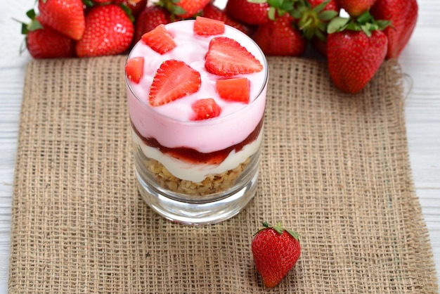 Home made granola breakfast with strawberries and plain yogurt, served in the glass.