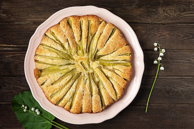 Home-made rhubarb pie, top view on dark vintage wooden background