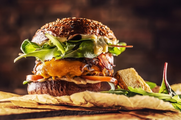 Home made tasty burger with bacon onion cheese ane lettuce on wooden box.