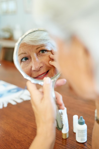 Photo home mirror and elderly woman for skincare checking and face inspection with hand gesture reflection mature person and beauty treatment for wrinkles anti aging and skin texture in house