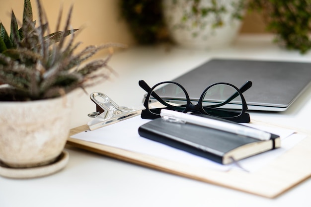 Home office with laptop plants and glasses