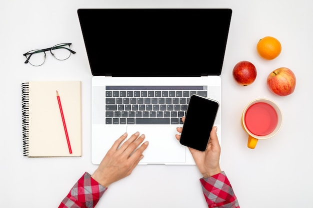 Home office workspace mockup. Laptop with blank screen, hands and accessories on white