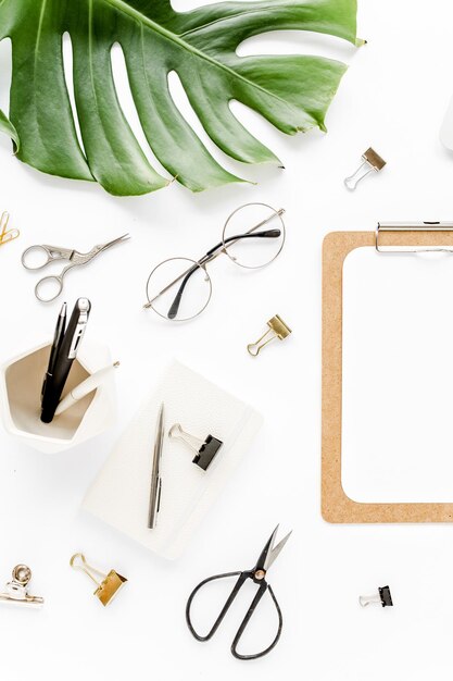 Home office workspace mockup with tropical leaves monstera clipboard and accessories on white backgr