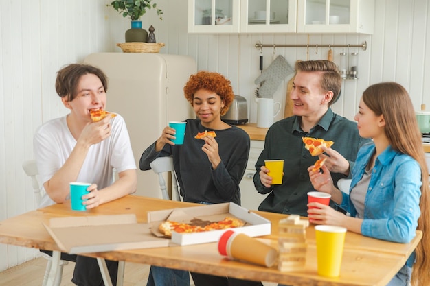 Home party overjoyed diverse friends eating ordered pizza for home party happy group mixed race youn