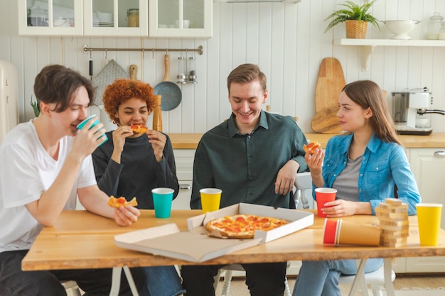 Home party overjoyed diverse friends eating ordered pizza for home party happy group mixed race youn