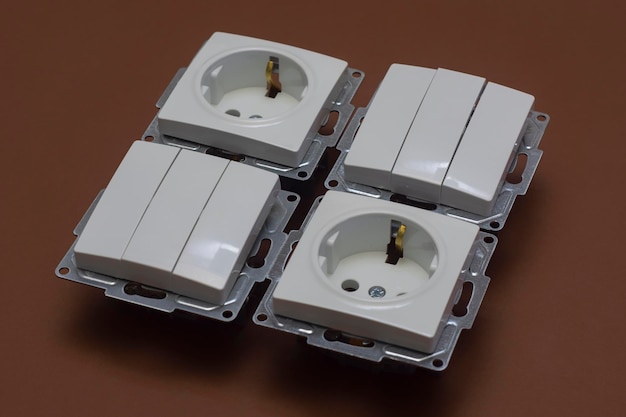 Home plastic sockets and switches for electricity on a brown background