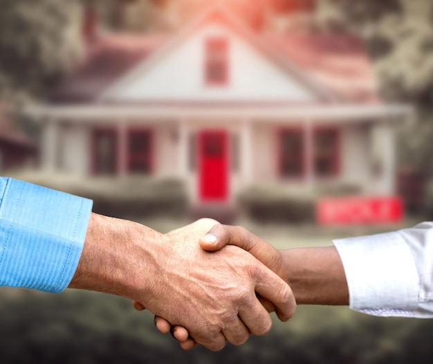 Home For Sale Real Estate Sign in Front of Beautiful New House Sold Blurred background Handshake