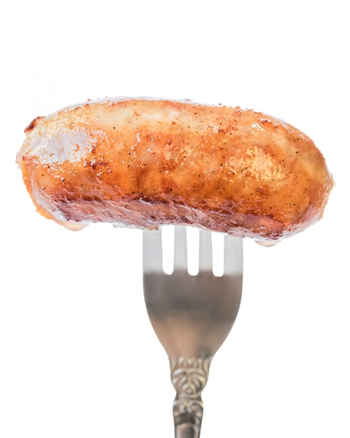 Home sausage fried in oil on a fork.