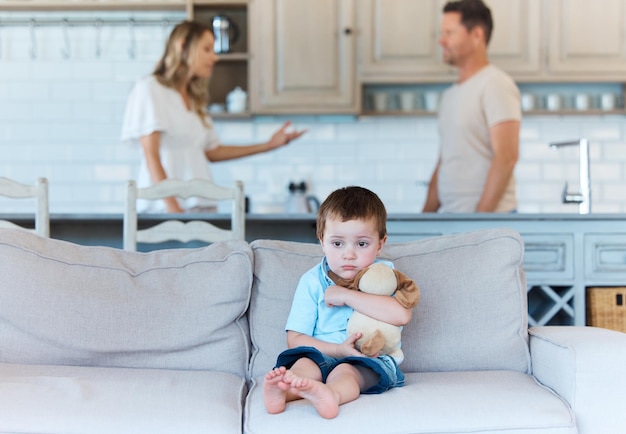 Home should be an anchor not a storm Shot of a scared boy on the couch while his parents are arguing at home