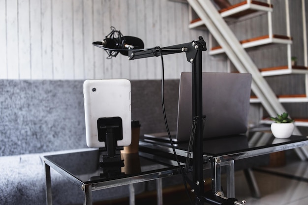 Home studio podcast interior. Microphone, laptop and mobile phone on the table