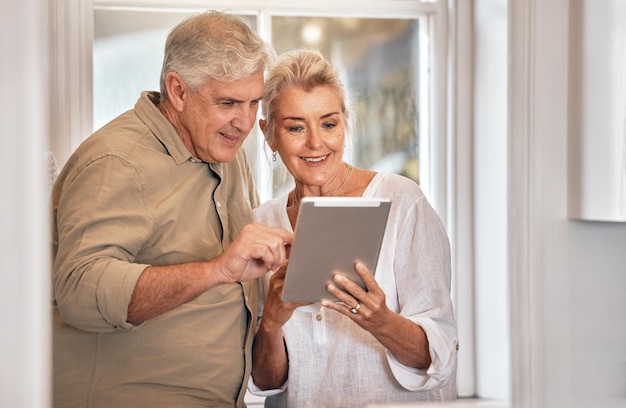 Home typing and senior couple with a tablet love and website information with social media chatting and sms Technology old man and elderly woman with happiness search internet and connection