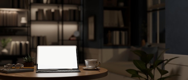 Home workspace at night in a modern dark room with tablet mockup and decor on table