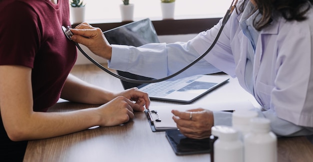 Homecare nursing service and elderly people cardiology healthcare Close up of young hispanic female doctor nurse check mature caucasian man patient heartbeat using stethoscope during visit