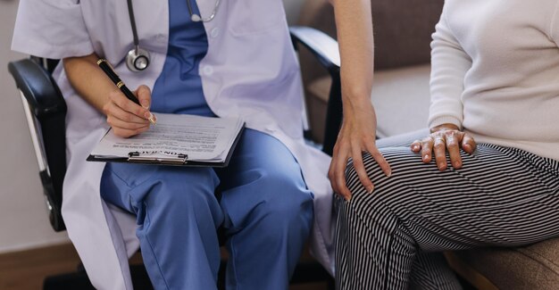 Homecare nursing service and elderly people cardiology healthcare Close up of young hispanic female doctor nurse check mature caucasian man patient heartbeat using stethoscope during visit