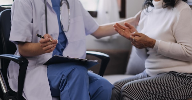 Homecare nursing service and elderly people cardiology healthcare Close up of young hispanic female doctor nurse check mature caucasian man patient heartbeat using stethoscope during visit