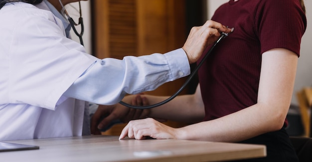 Homecare nursing service and elderly people cardiology healthcare Close up of young hispanic female doctor nurse check mature caucasian man patient heartbeat using stethoscope during visit