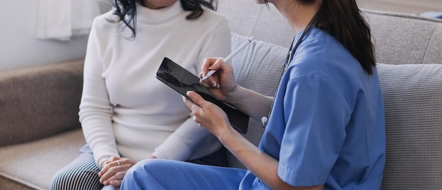 Homecare nursing service and elderly people cardiology healthcare Close up of young hispanic female doctor nurse check mature caucasian man patient heartbeat using stethoscope during visit