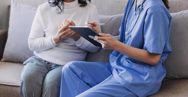 Homecare nursing service and elderly people cardiology healthcare Close up of young hispanic female doctor nurse check mature caucasian man patient heartbeat using stethoscope during visit