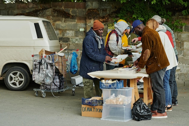 Homeless people getting food from volunteers