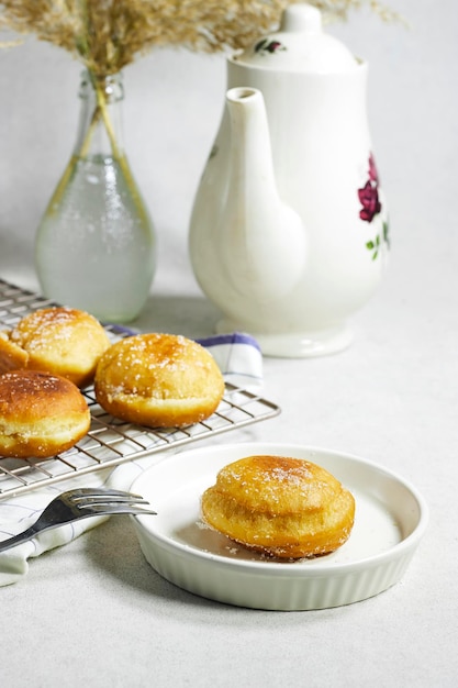 homemade Algeria Donut with apricot jam and powdered with sugar bottle of milk and reeds vase