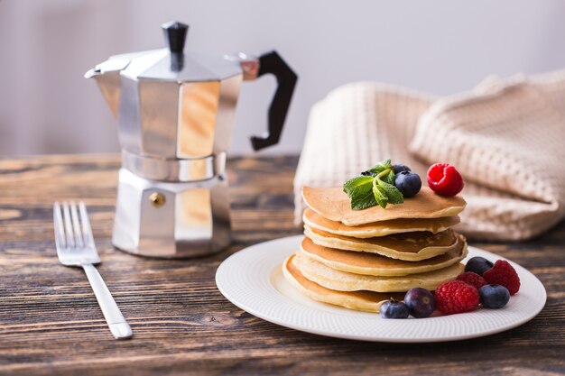 Homemade american pancakes with fresh blueberry and raspberries. Healthy morning breakfast. Rustic