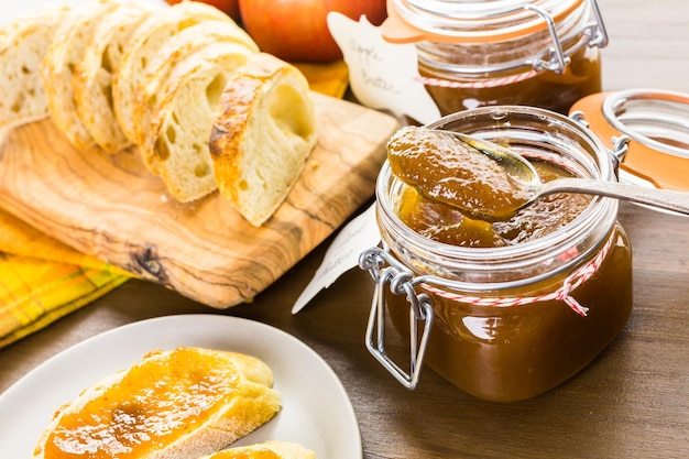 Homemade apple butter and freshly baked bread on the table.