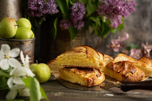 homemade apple cinnamon scones with lilac flowers and apple blooming branches. English breakfast or brunch at the village