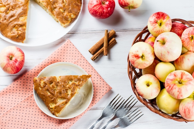 Homemade apple pie with cinnamon and fresh ripe apples in the background