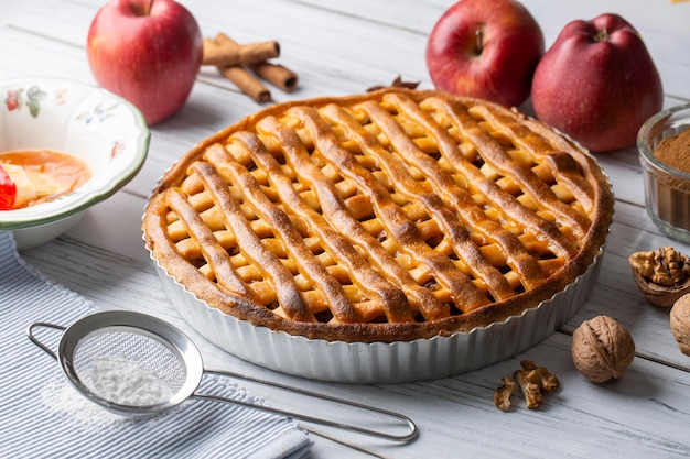 Homemade Apple Pies on a white wooden background, top view. The classic fall Thanksgiving dessert - organic apple pie.