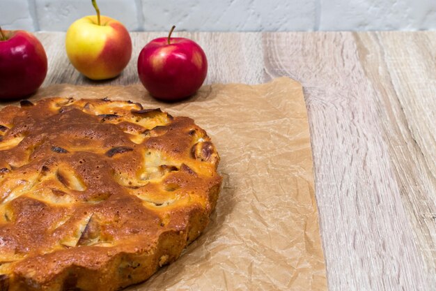 Homemade baked apple pie in a plate on a wooden table ready to eat Place for an inscription