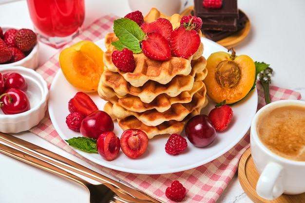 Homemade baked traditional Belgium waffles with berry fruits and cup of coffee, selective focus