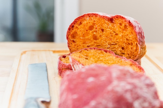 Homemade beetroot Italian ciabatta bread cut in slices on wooden board