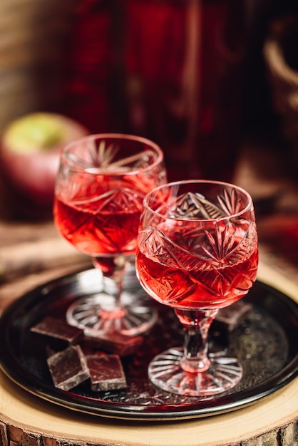 Homemade berry alcoholic beverage and chocolate bars on metal tray