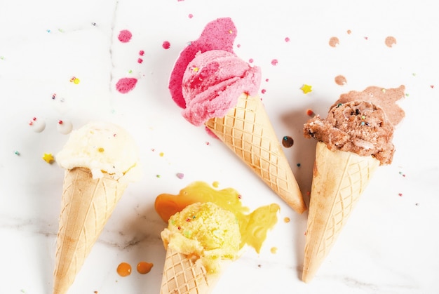 Homemade berry vanilla caramel chocolate ice cream in waffle cones white marble background 