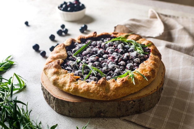 Homemade blackcurrant galette on old concrete background