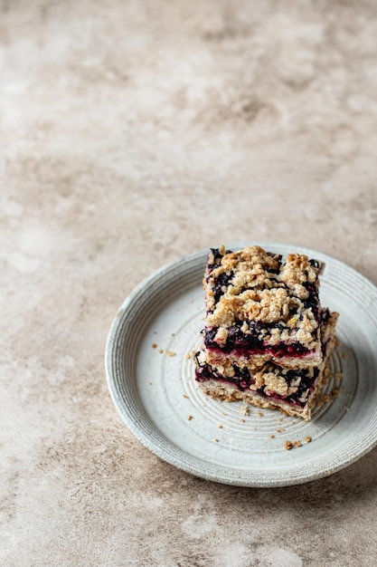 Homemade blueberry crumble bars on a plate on beige background isolated with text space