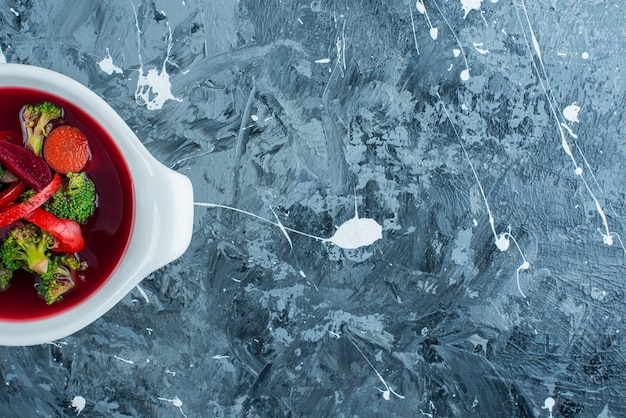 Homemade borsch soup in a bowl on the blue surface