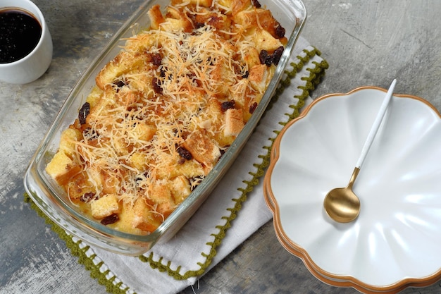 Homemade bread butter pudding with raisins and grated cheese as topping